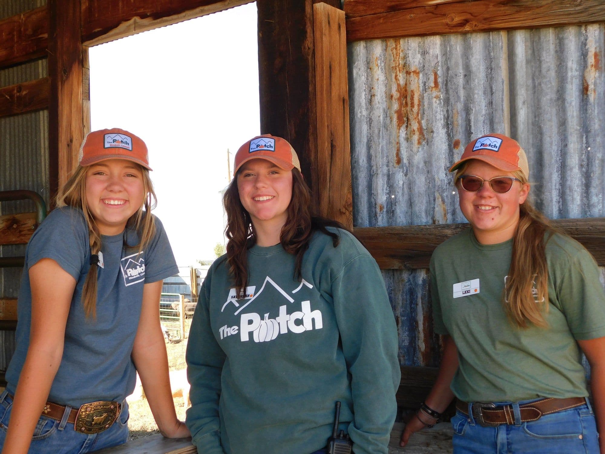 Three farmhands in The Patch shirts on the farm